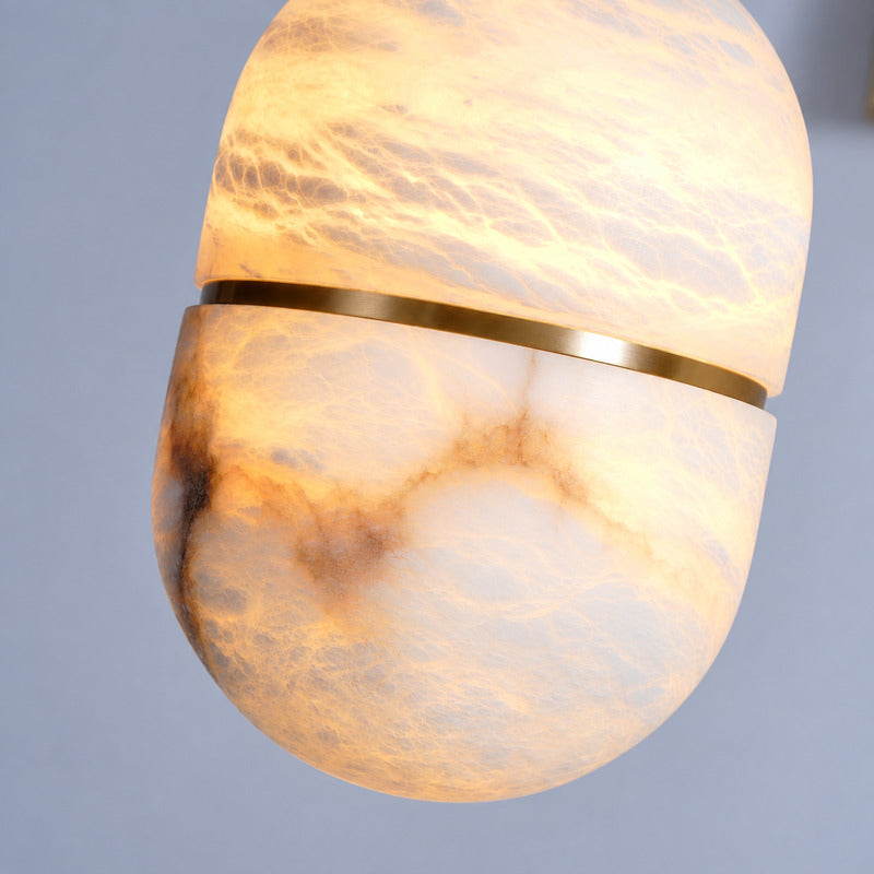 Warm glow diffusing softly through the alabaster bowl of the Ciotola pendant