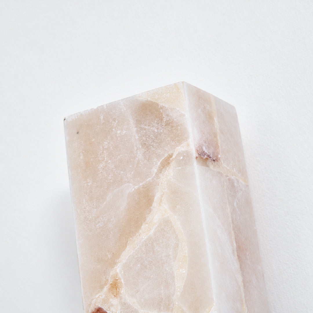 Close-up of natural veining glowing through the alabaster cylinder of the Colonna sconce