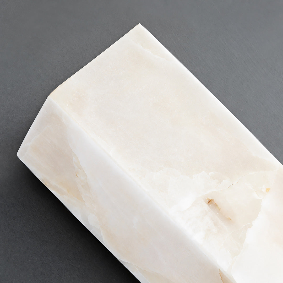 Close-up of natural veining glowing through the alabaster cylinder of the Colonna sconce
