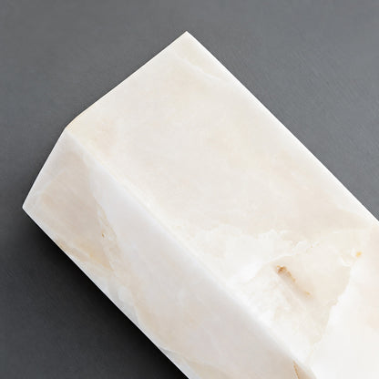 Close-up of natural veining glowing through the alabaster cylinder of the Colonna sconce