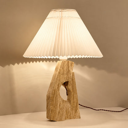 Colonna travertine table lamp illuminated warm elegant glow natural travertine stone fabric shade cozy white background