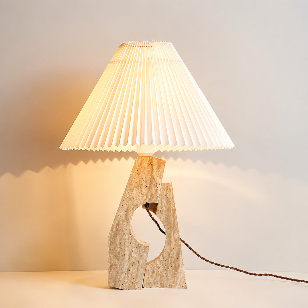 Colonna travertine table lamp illuminated warm elegant glow natural travertine stone fabric shade cozy white background