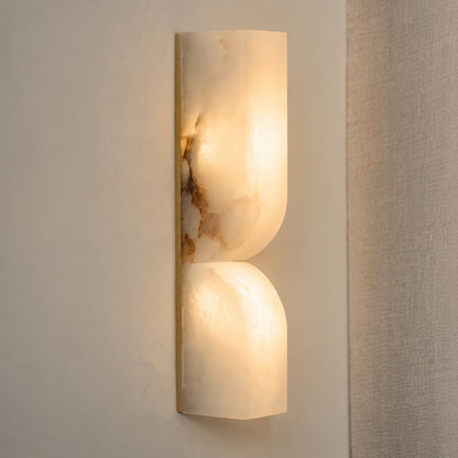 Contatto alabaster wall sconce illuminated glowing veining warm soft radiance translucent carved stone detail close up quiet luxury