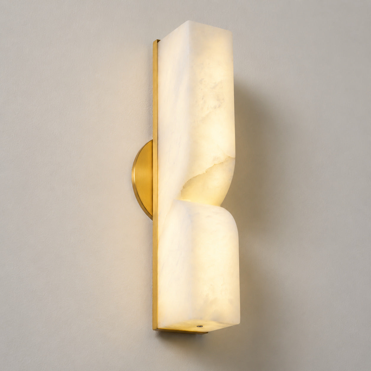Contatto alabaster wall sconce illuminated glowing veining warm soft radiance translucent carved stone detail close up quiet luxury