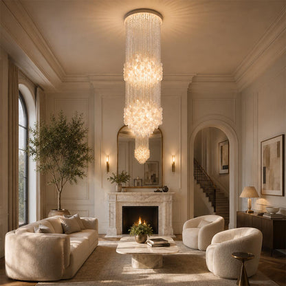 Long Coralia FUN tall style staircase shell chandelier in a high-ceiling living room with cream sofas and a fireplace.