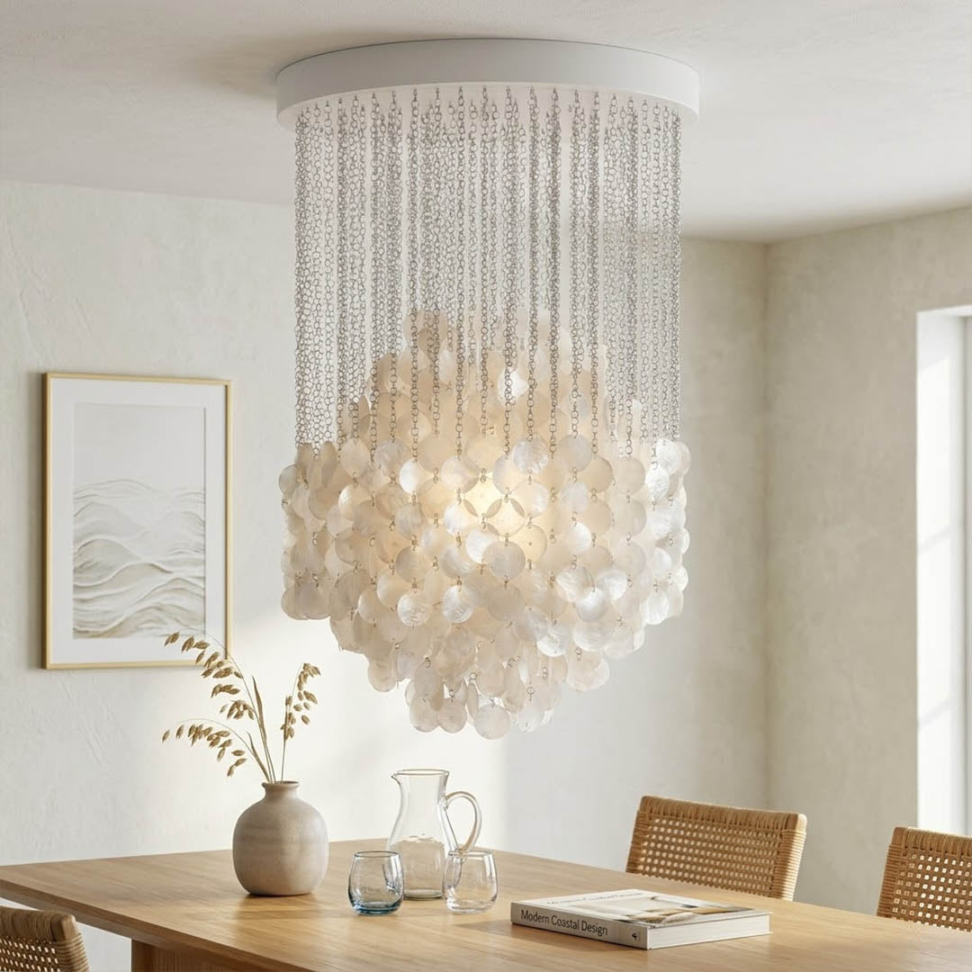 Coralia illuminated FUN tall staircase shell chandelier from second floor landing view evening warm 2700K glow Capiz pearl shells Mid Century designer lifestyle interior