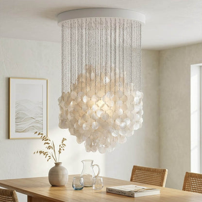 Coralia illuminated FUN tall staircase shell chandelier from second floor landing view evening warm 2700K glow Capiz pearl shells Mid Century designer lifestyle interior