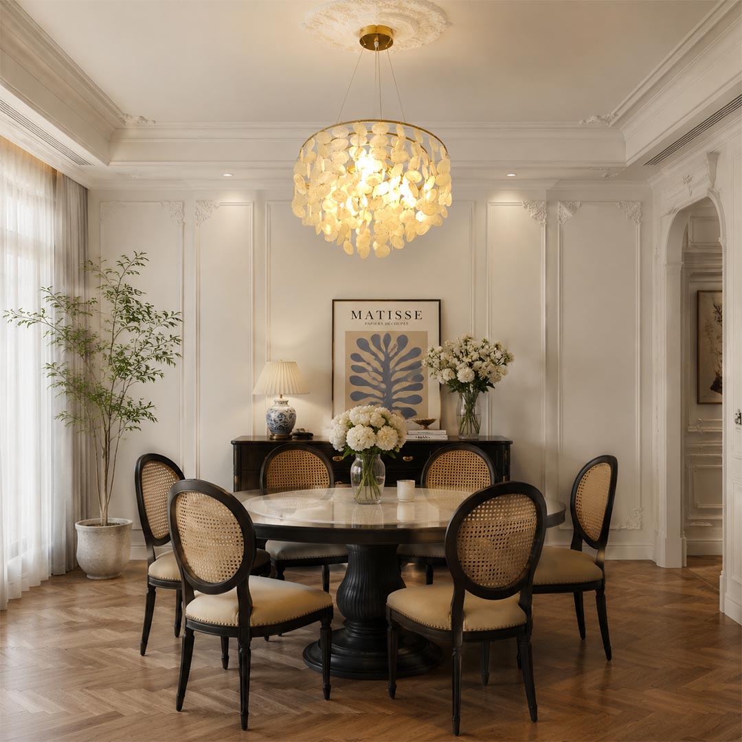 Coraline capiz shell wind chime chandelier suspended over a round wooden dining table