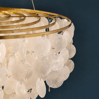 Close-up view of the brass gold frame and cascading translucent capiz shell discs on the chandelier