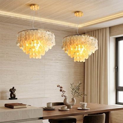 Coraline Capiz shell wind chime chandelier coastal primary bedroom romantic natural beach house warm soft glow lifestyle interior
