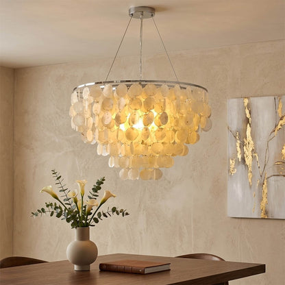 Coraline Capiz shell wind chime chandelier beach house dining room Coastal Hampton white wood interior warm glow natural lifestyle