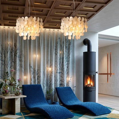 Coraline Capiz shell wind chime chandelier coastal primary bedroom romantic natural beach house warm soft glow lifestyle interior