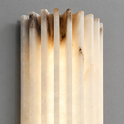 Costa ribbed alabaster wall light illuminated glowing ribbed veining warm soft radiance translucent stone detail close up quiet luxury