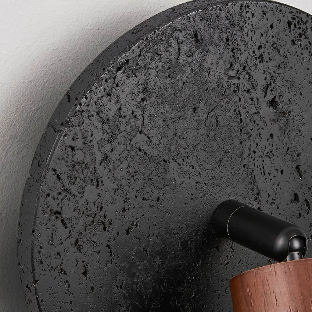 Cove wall sconce black travertine natural stone texture surface detail close up