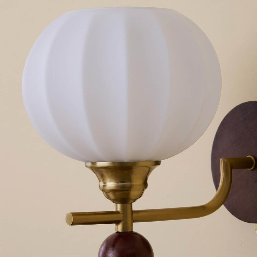 Crescent wall lamp curved metal arm wood base frosted glass globe detail close up