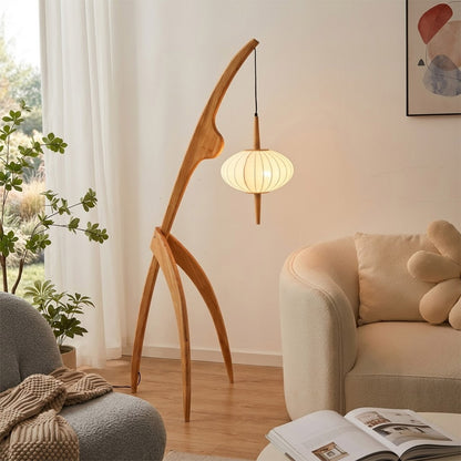 Cygnus walnut wood floor lamp behind sofa living room long arm reaching over seating warm silk glow transitional interior