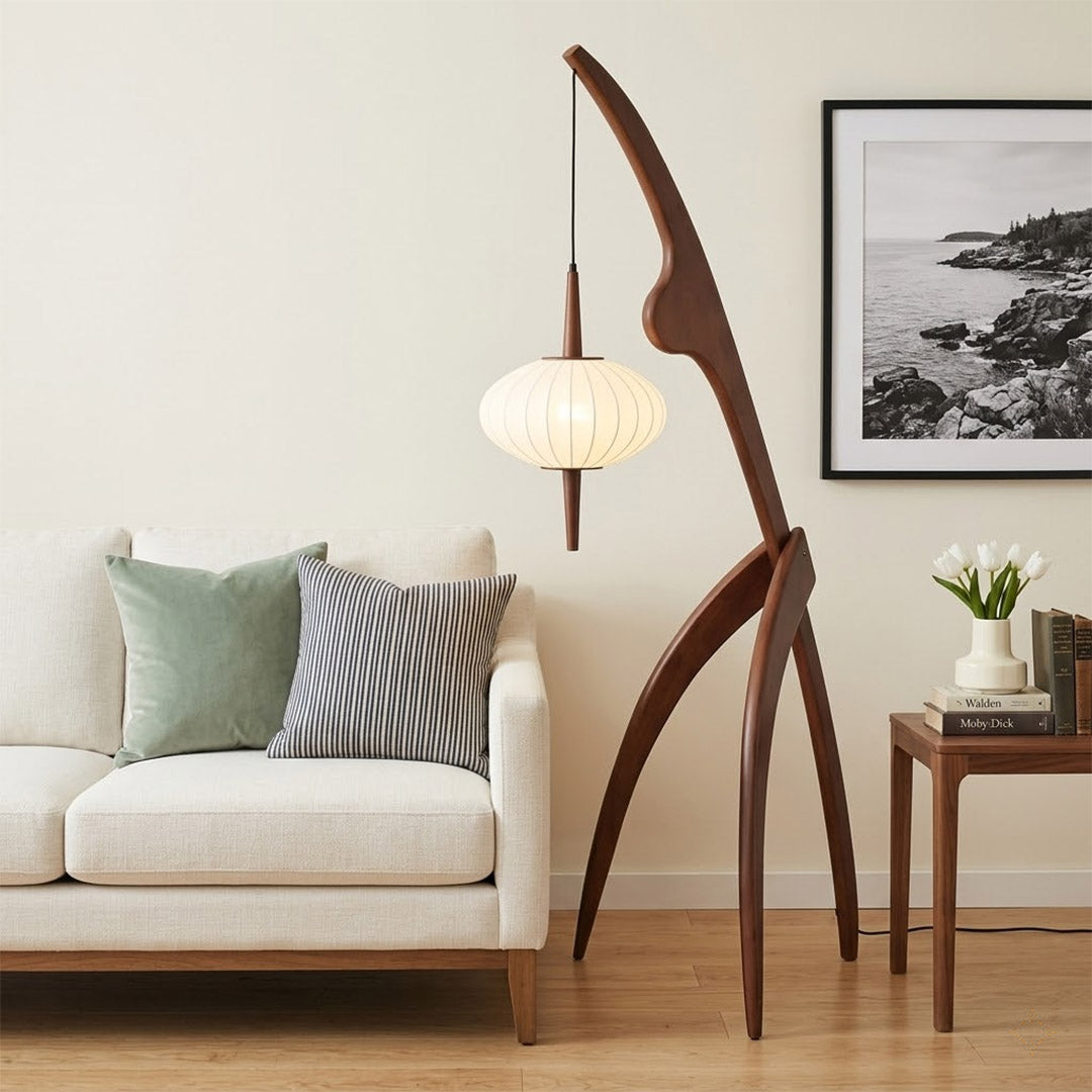 Cygnus walnut wood floor lamp behind sofa living room long arm reaching over seating warm silk glow transitional interior