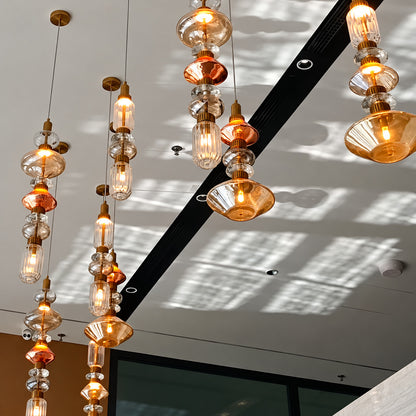 Six-head Danza glass pendant cluster as a focal point in a hotel lobby