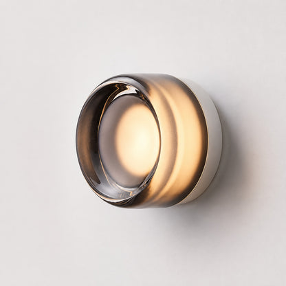 Model A smooth smoke gray glass Demi wall sconce adding a soft moody accent to a living room
