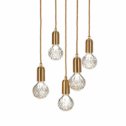 Diamante glass pendant light with a faceted cut-glass crystal-bulb shade glowing warm over a kitchen island