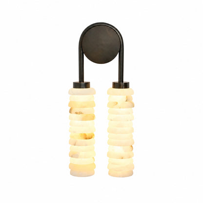 Duetto alabaster wall sconce with two ribbed columns of natural stone glowing warm on a wall