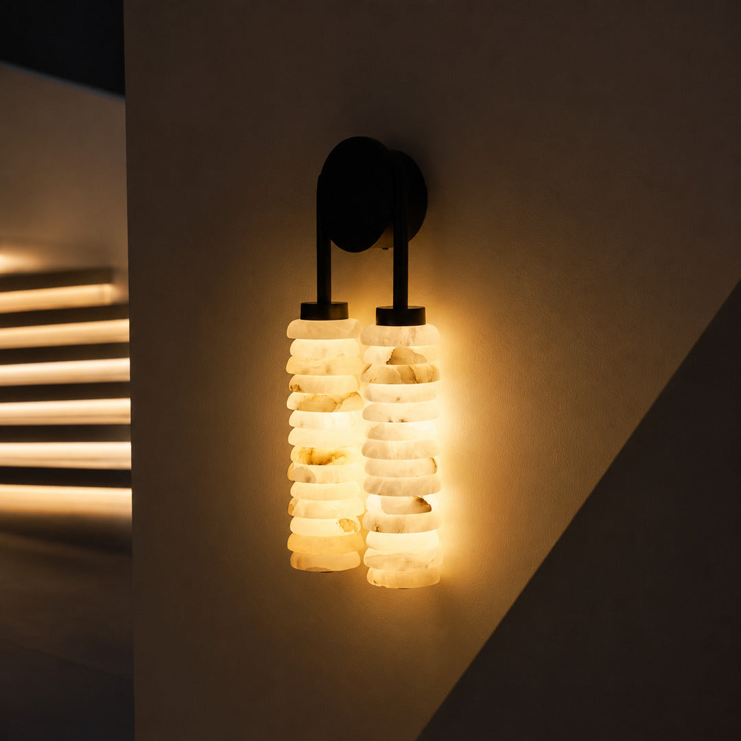 Duetto alabaster wall sconce lighting a staircase wall with a soft natural-stone glow