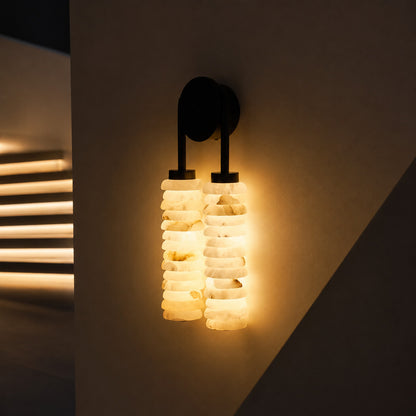 Duetto alabaster wall sconce lighting a staircase wall with a soft natural-stone glow