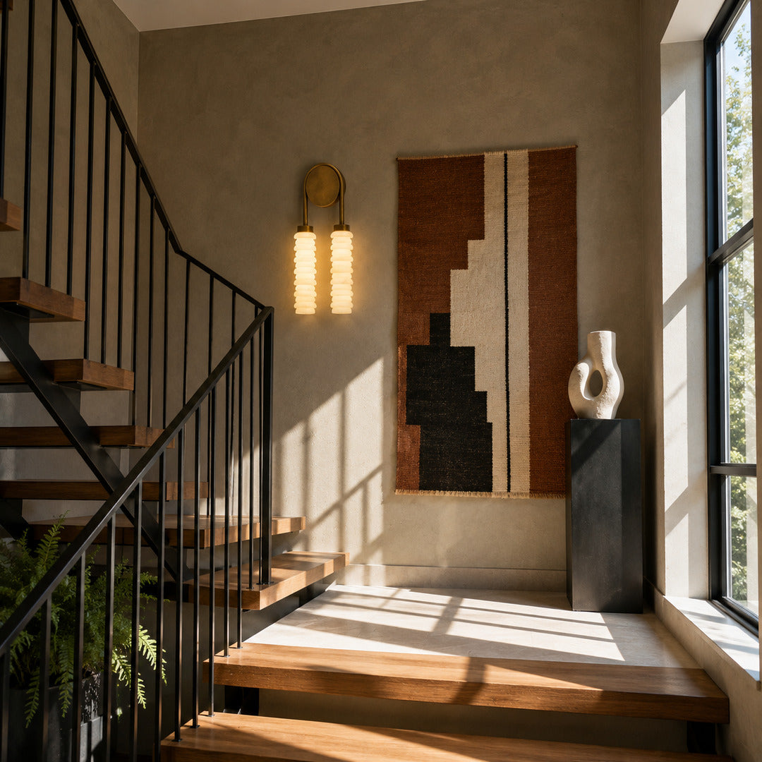 Duetto alabaster wall sconce lighting a staircase wall with a soft natural-stone glow