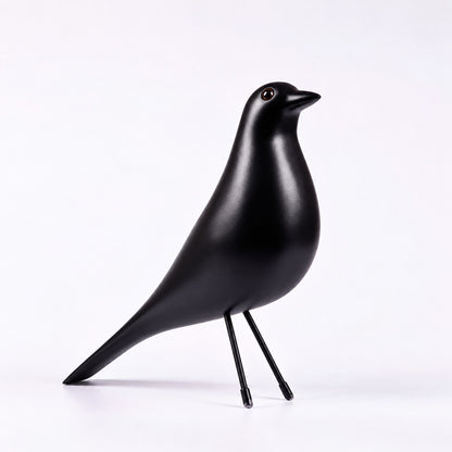 Black Eames House Bird sculpture as a bold mid-century accent on a bookshelf