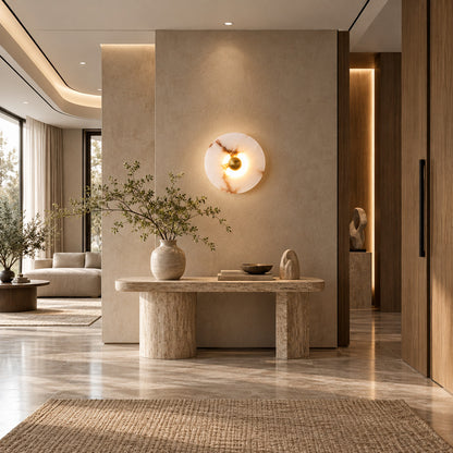 Eclisse alabaster wall sconce welcoming guests with a warm round glow above an entry console