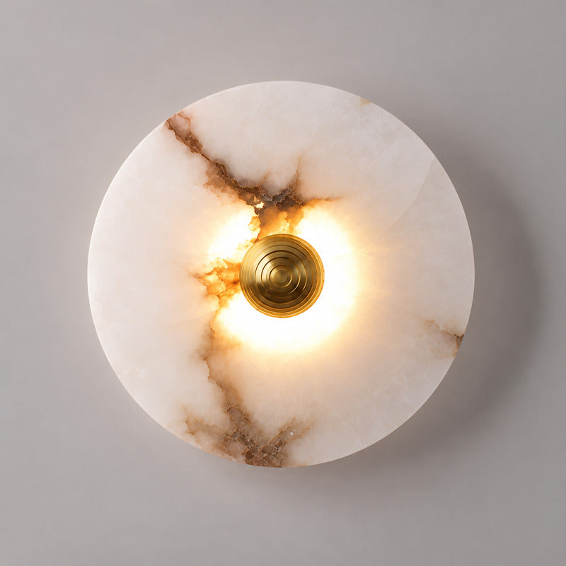 Close-up of the round translucent alabaster disc on the Eclisse wall sconce lit softly from within