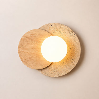 Eclisse travertine wall sconce illuminated warm even glare-free glow white glass globe travertine wood white background