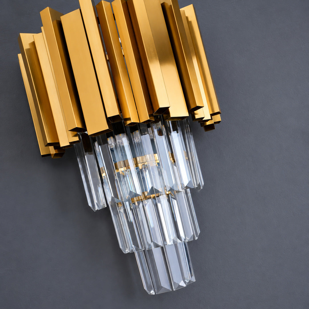 Warm light refracting through the precision-cut crystals of the Empire wall sconce scattering glints on the wall