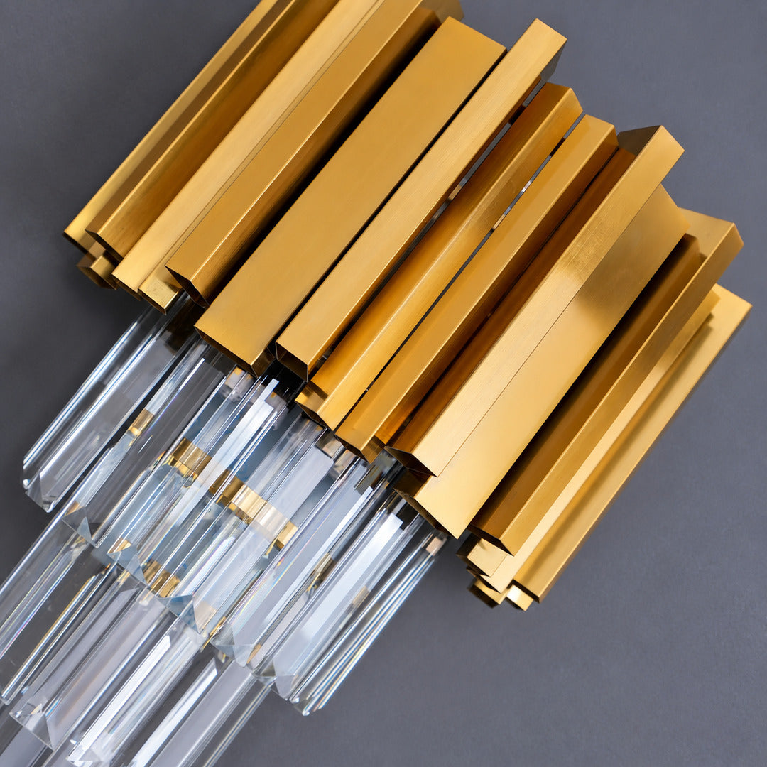 Warm light refracting through the precision-cut crystals of the Empire wall sconce scattering glints on the wall