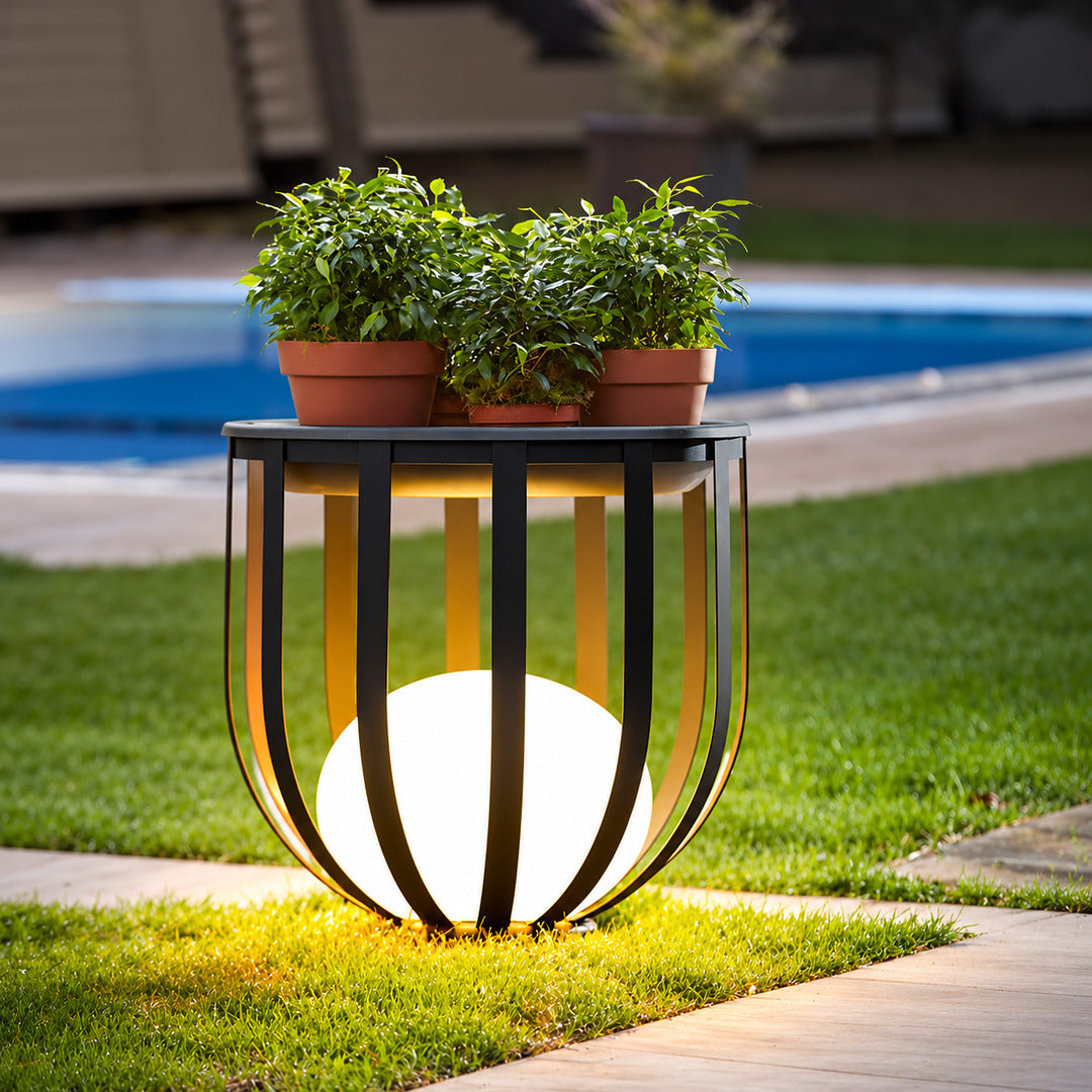 Row of Faceta outdoor garden lights marking a garden pathway with warm light