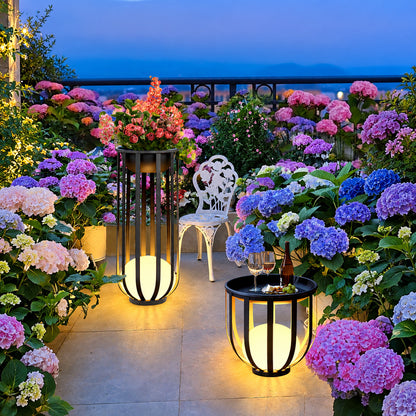 Faceta outdoor garden lights glowing warmly across a garden lawn at dusk