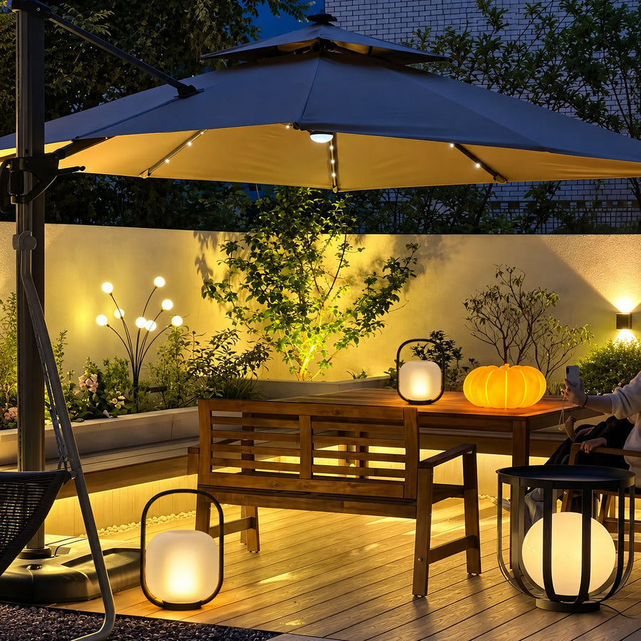 Falo portable lantern glowing warmly on a patio dining table at dusk