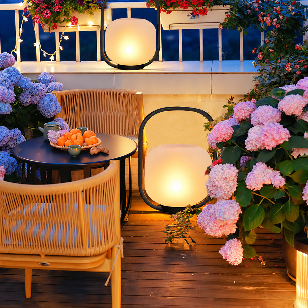 Falo portable lantern lighting a garden seating area with a soft warm glow