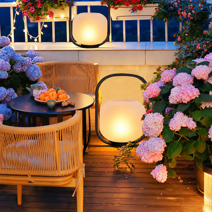 Falo portable lantern lighting a garden seating area with a soft warm glow