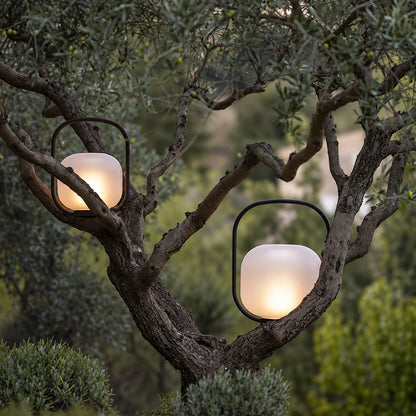 Falo portable lantern lighting a garden seating area with a soft warm glow