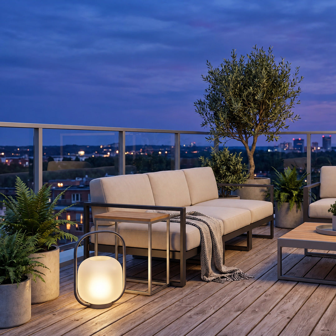 Falo portable lantern glowing warmly on a patio dining table at dusk