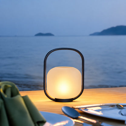 Several Falo portable lanterns lining an outdoor dining table for an evening party