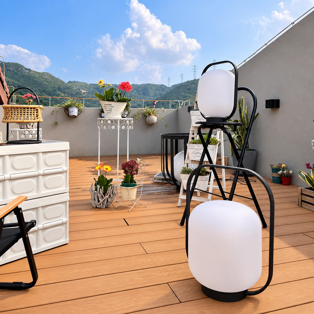 Falo portable lantern glowing warmly on a patio dining table at dusk