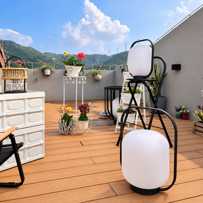 Falo portable lantern glowing warmly on a patio dining table at dusk