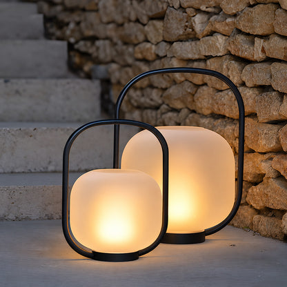 Several Falo portable lanterns lining an outdoor dining table for an evening party