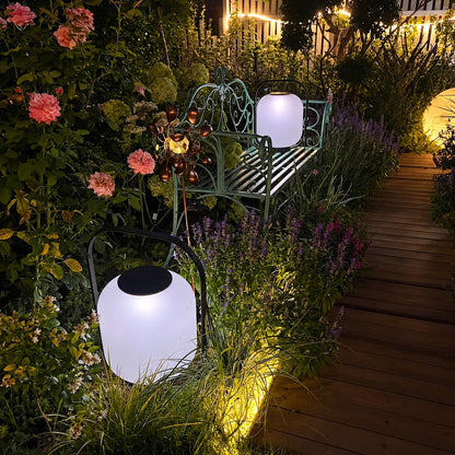 Falo portable lantern glowing warmly on a patio dining table at dusk