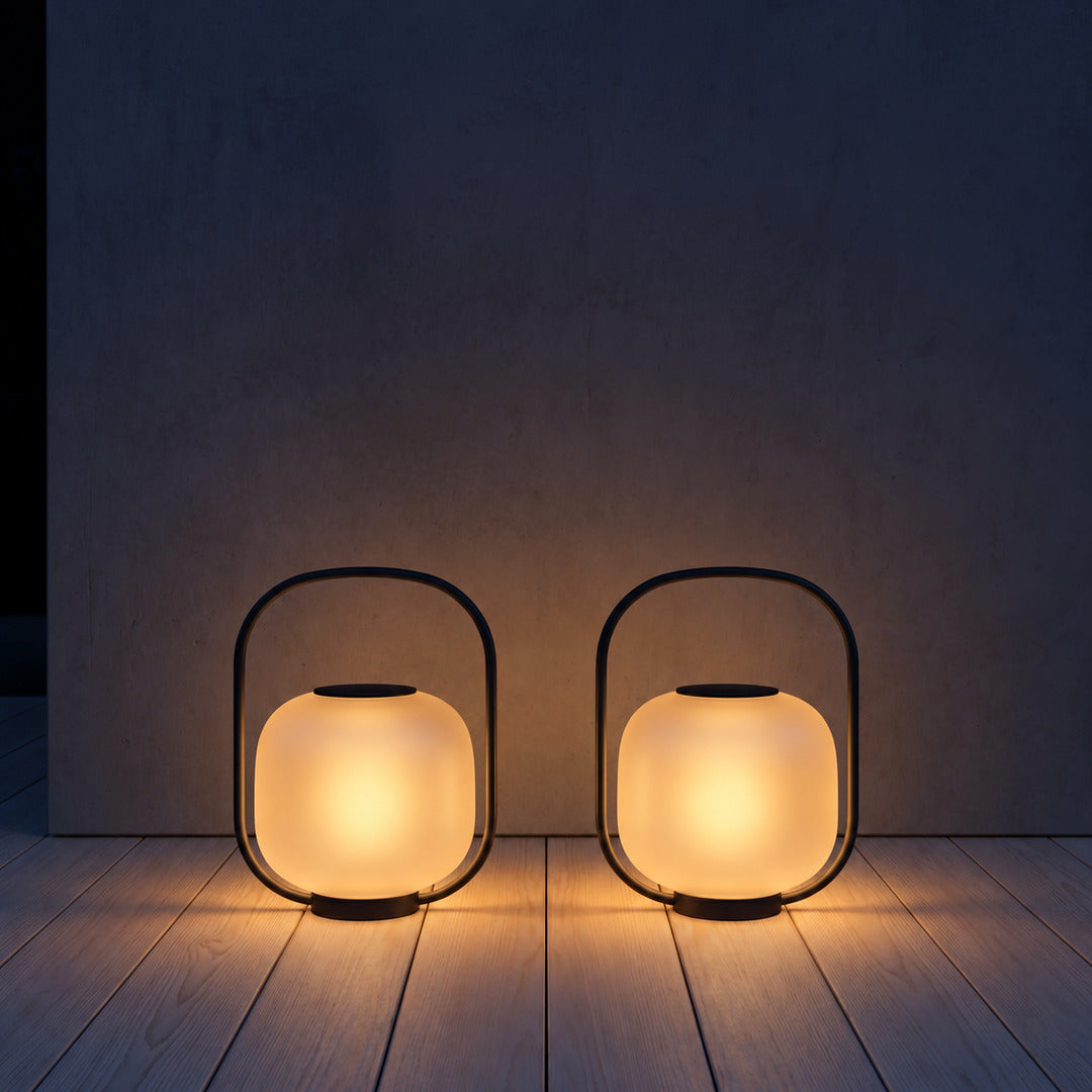Falo portable lantern lighting a covered porch or garden pathway with warm light