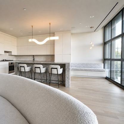 Flutto alabaster chandelier suspended over a modern kitchen island as a linear statement