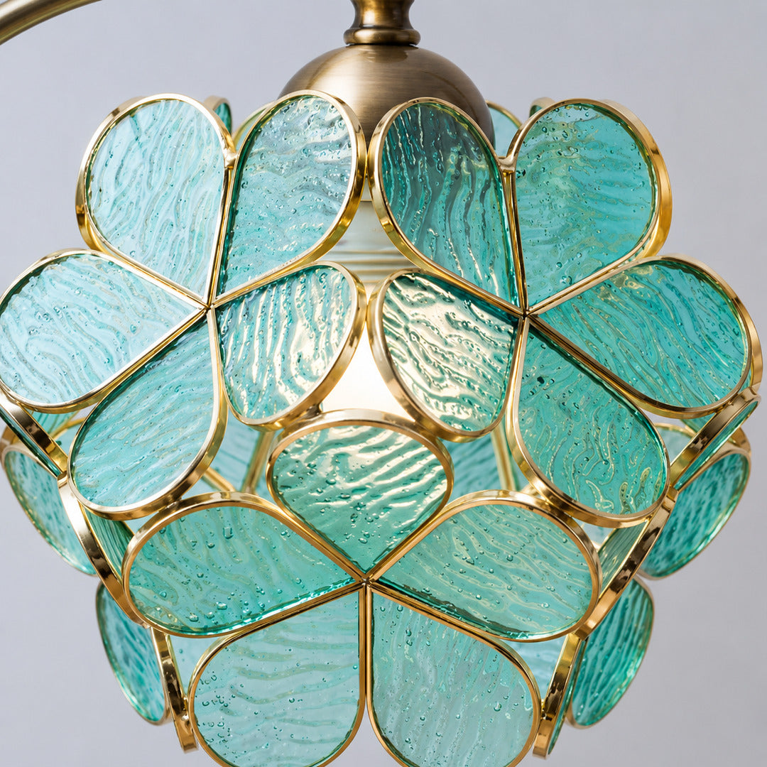 Close-up of the green glass leaves suspended from the brass arm of the Foglia table lamp