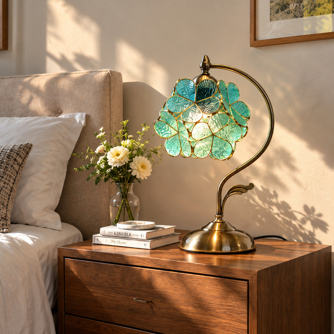 Foglia glass leaf table lamp casting a soft warm glow on a bedroom nightstand